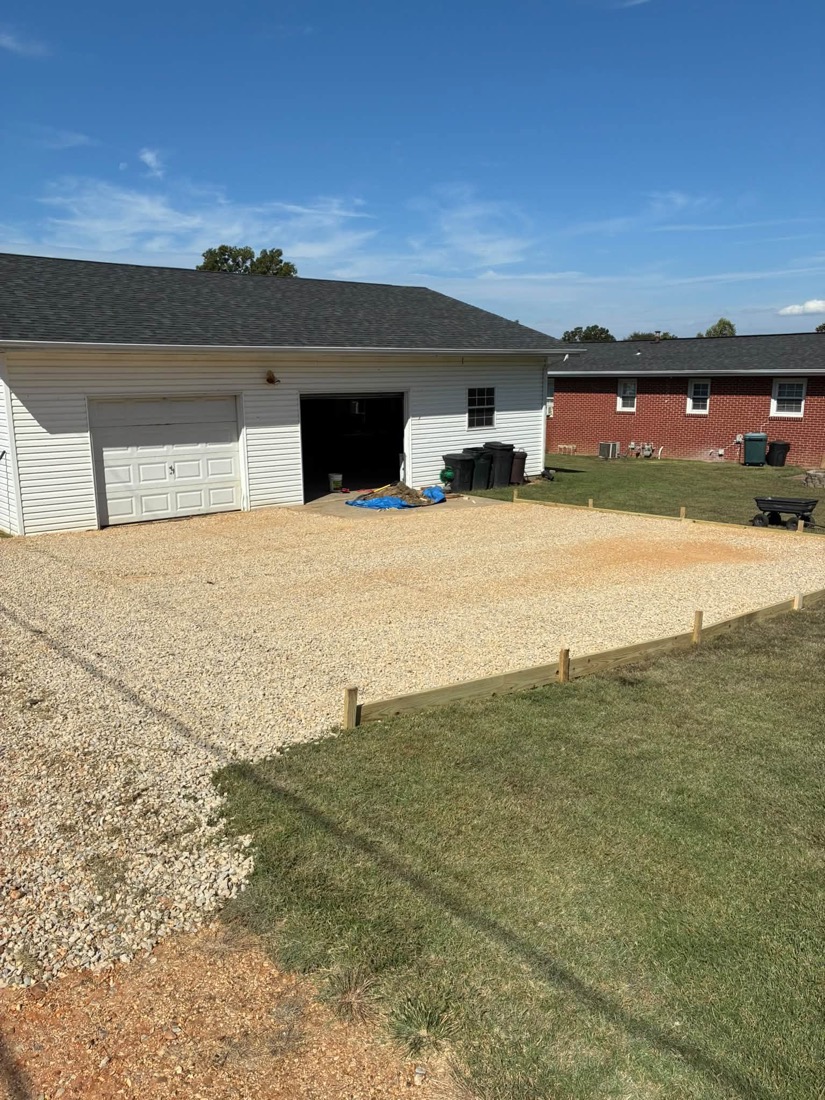 Gravel spread within the framed project area beside the garage